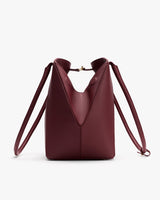 Leather handbag with long straps and clasp closure.