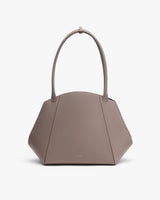 Handbag with long handles and geometric shape.