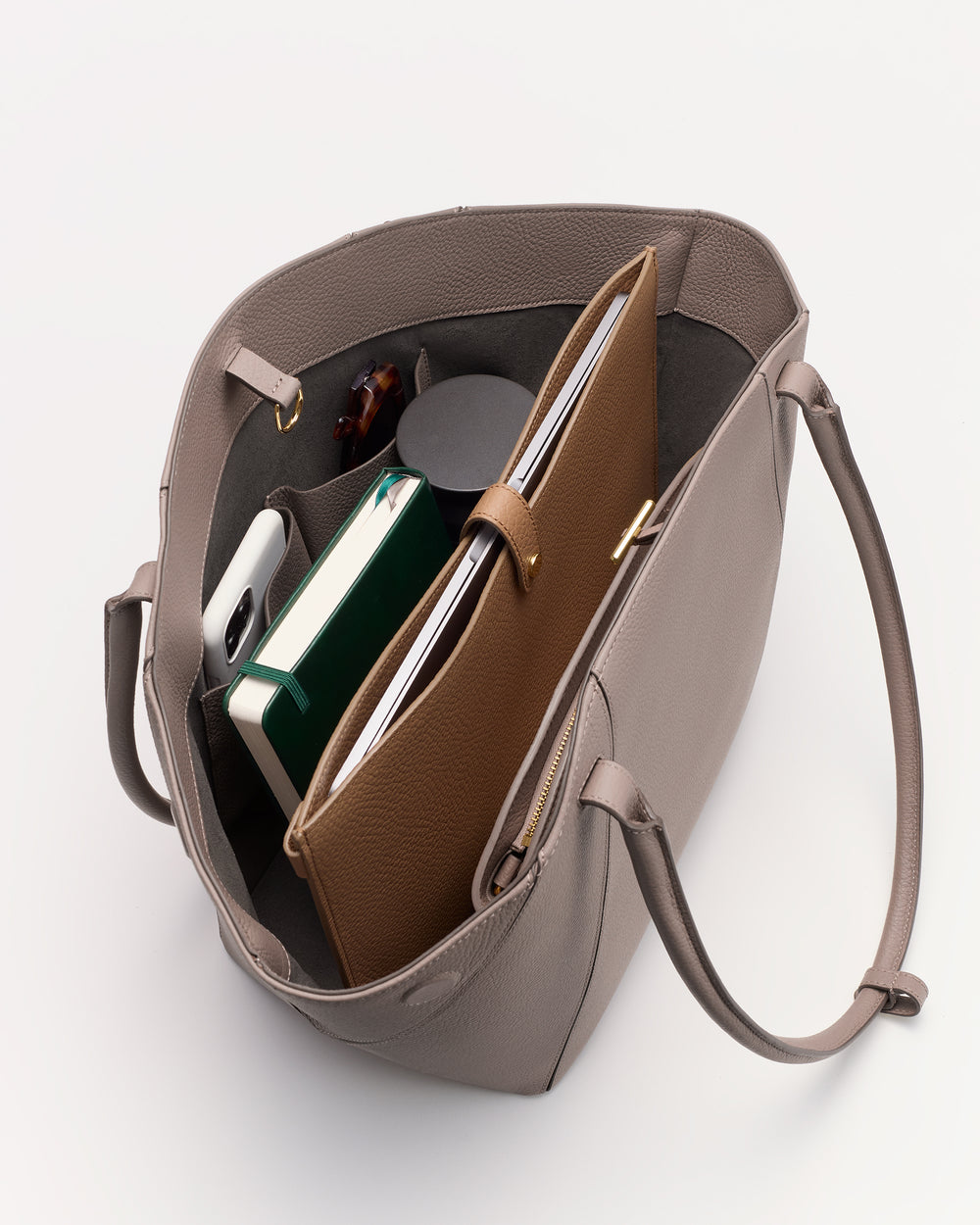 Open tote bag with books, phone, and pouch inside.