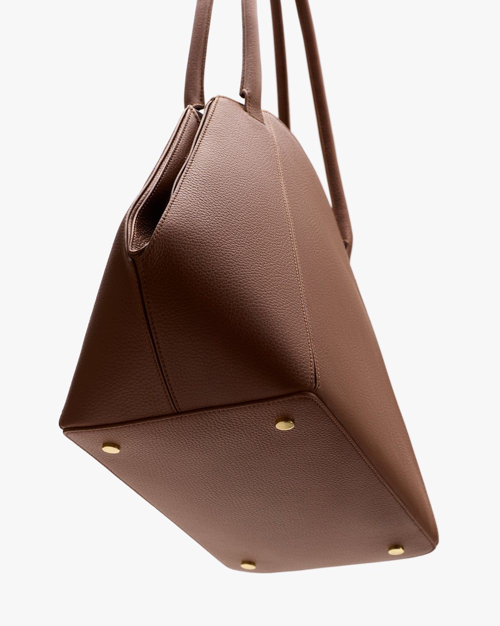 Tote bag with two handles and four small metal studs on the bottom.