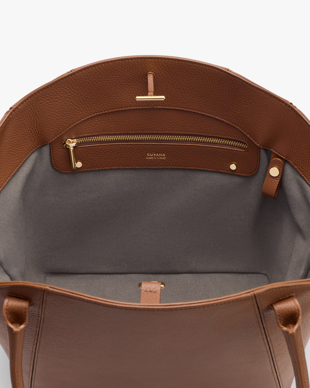 Open handbag showing inner pocket with zipper and a small buttoned strap.