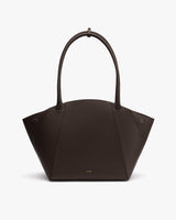 Handbag with a curved top and two long handles.