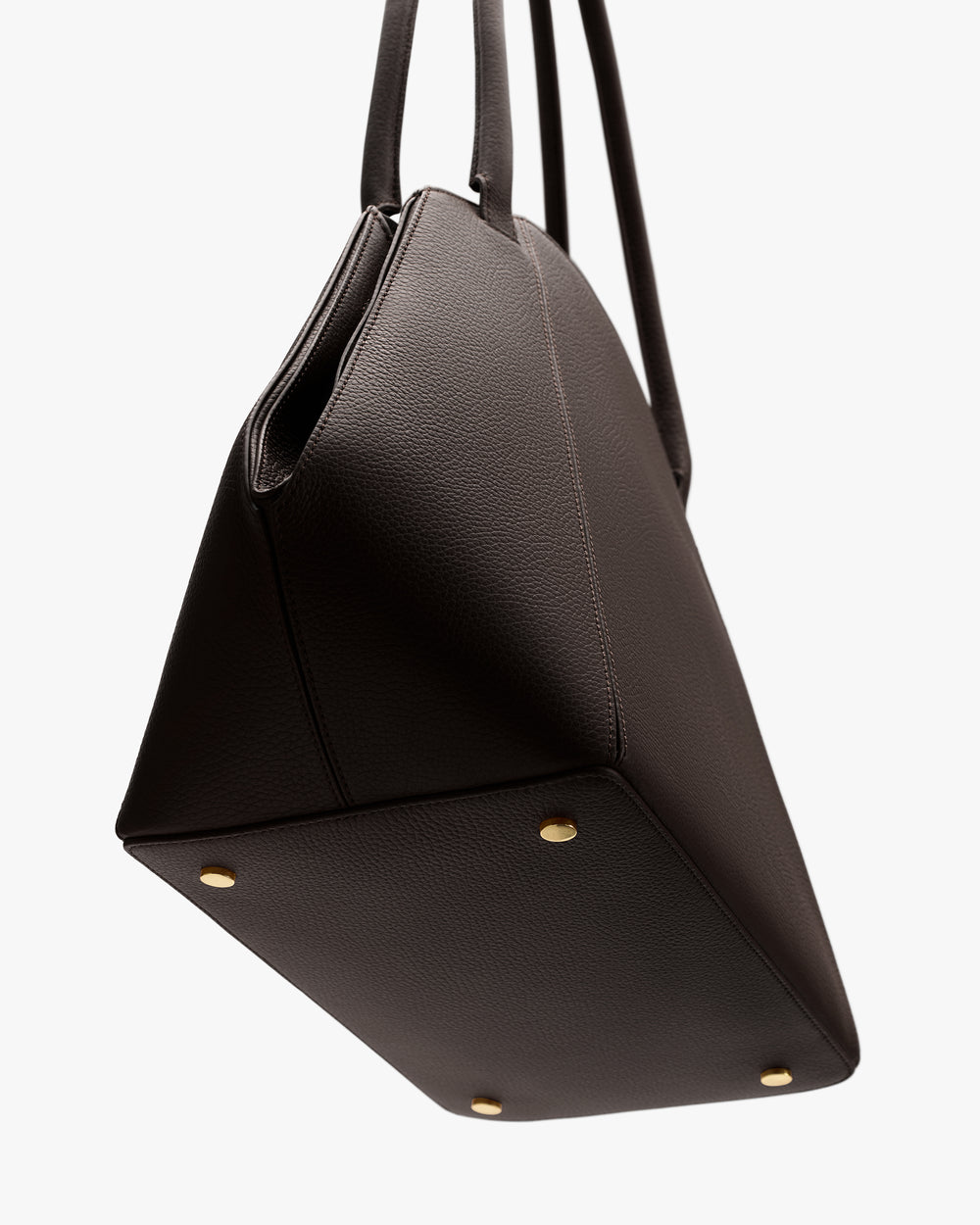 Tote bag with gold studs on the bottom, shown from a side angle.