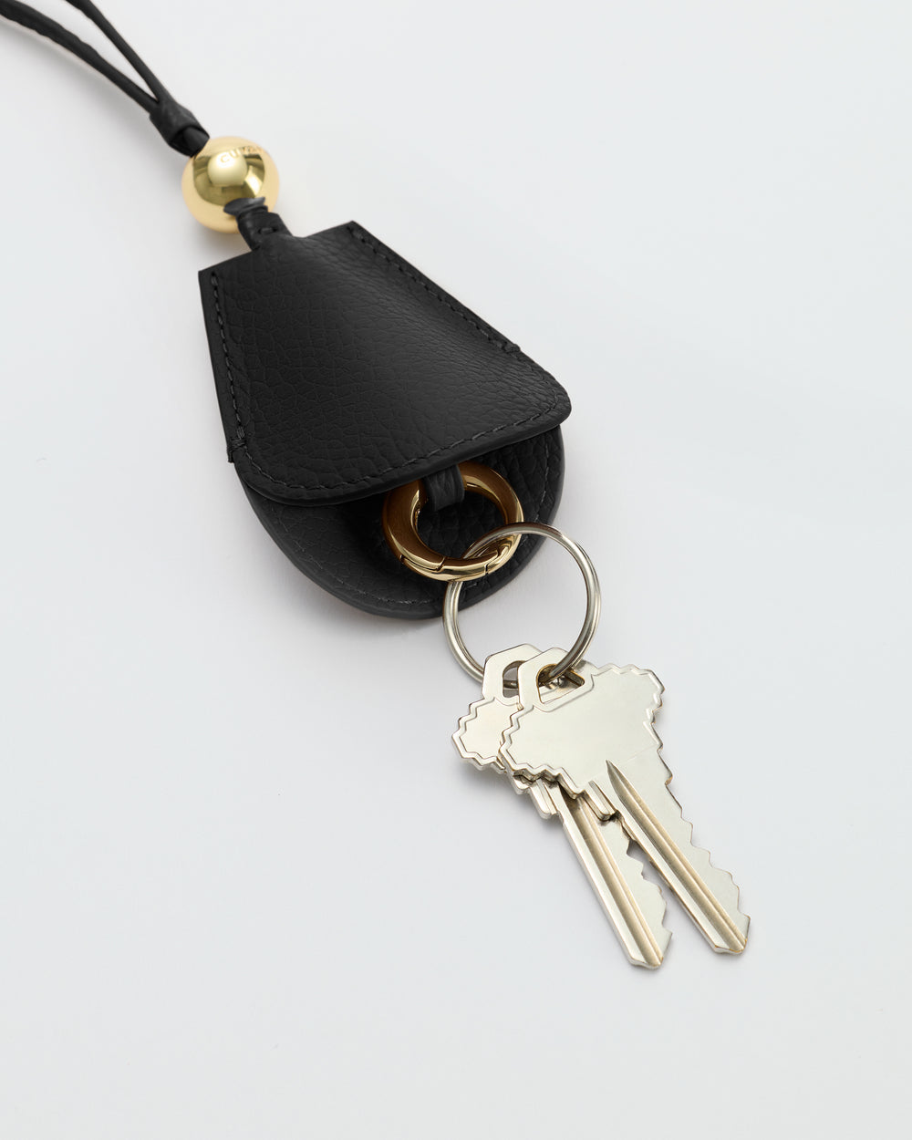 Keychain with attached keys on a leather holder with a metal ring and loop.