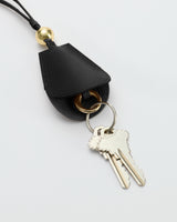 Keychain with attached keys on a leather holder with a metal ring and loop.