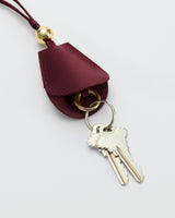 Keychain with two keys attached to a leather holder with a decorative bead.