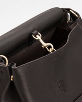 Open handbag with metal clasp and wide interior pocket.
