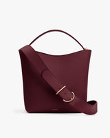 A handbag with a wide shoulder strap and handle.