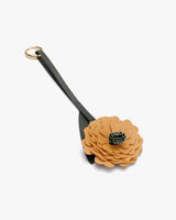 Keychain with flower-shaped charm attached by a strap and metal ring.