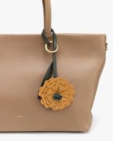 Tote bag with a floral charm attached to the handle
