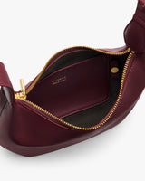 Open leather handbag with visible interior and zipper.