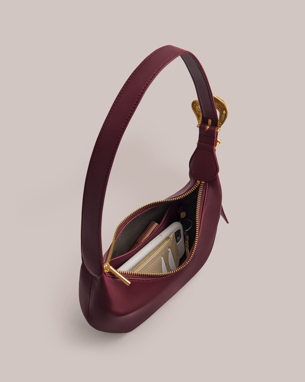 Small handbag with a zipper, revealing a phone and wallet inside.