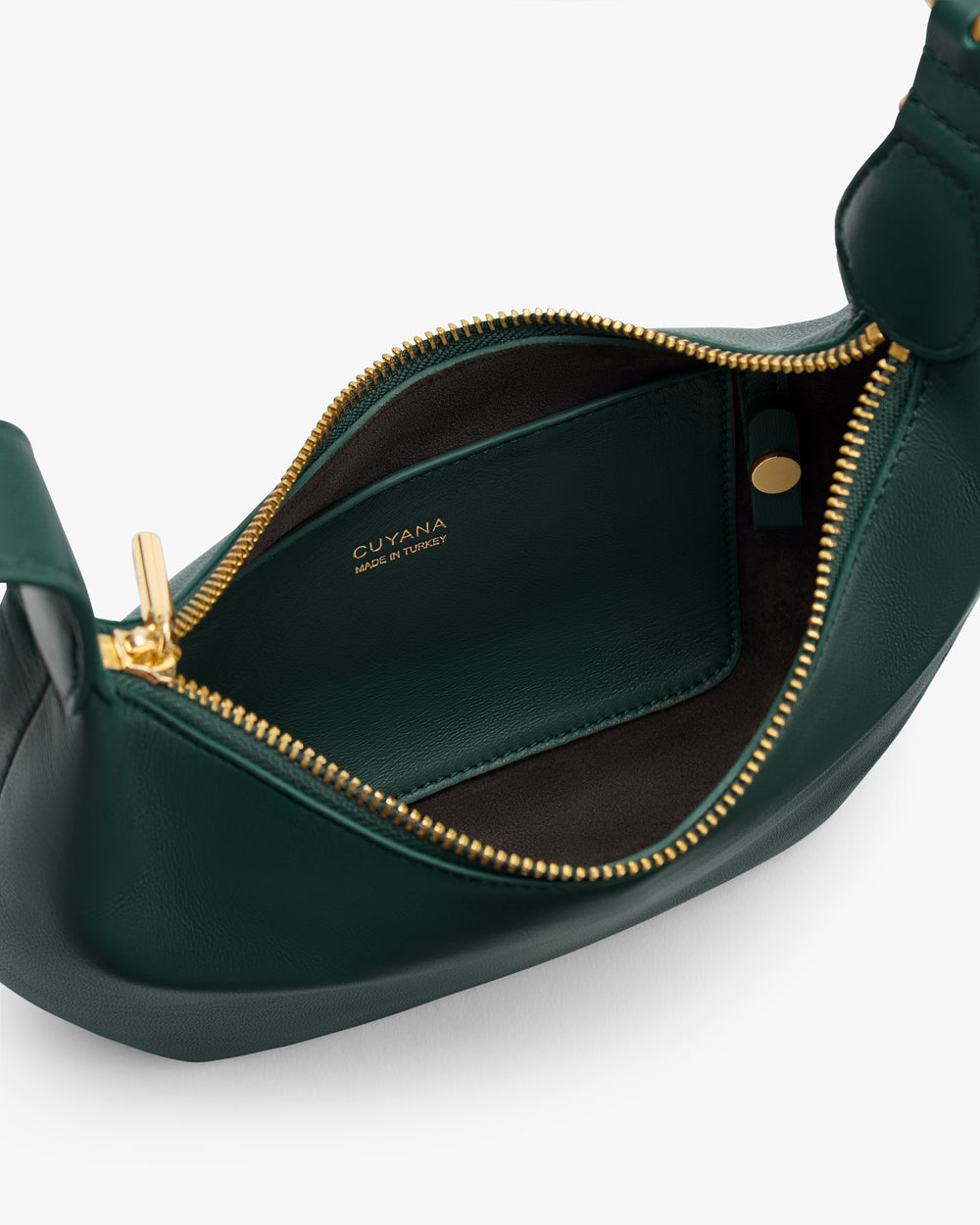 Open leather bag with visible zip and branded interior label.