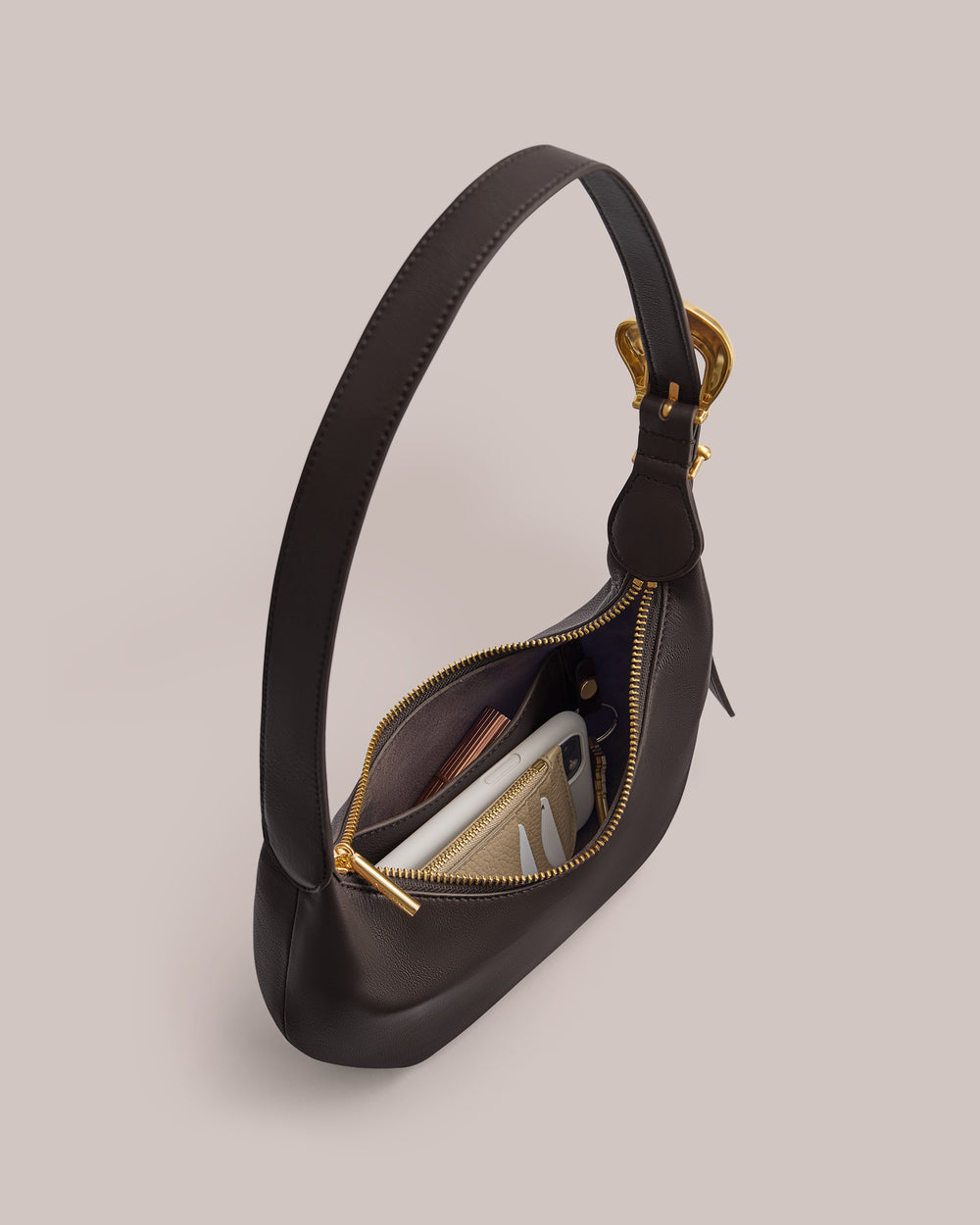 Shoulder bag with open zipper and items inside.