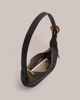 Shoulder bag with open zipper and items inside.