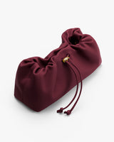 Soft clutch handbag with drawstring closure.