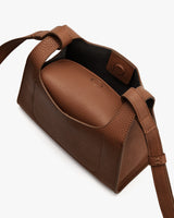 Open handbag with visible shoulder strap and magnetic closure.