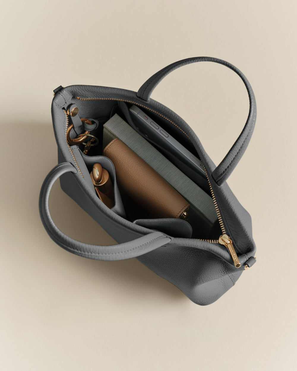 Open handbag with books and accessories inside