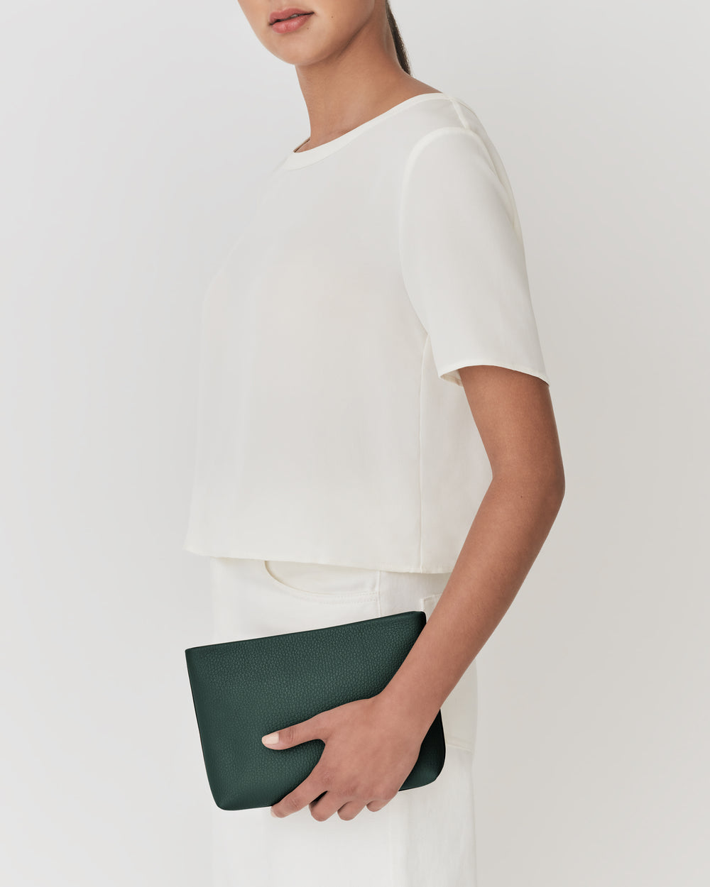 Person holding a clutch against their side.