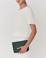 Person holding a clutch against their side.
