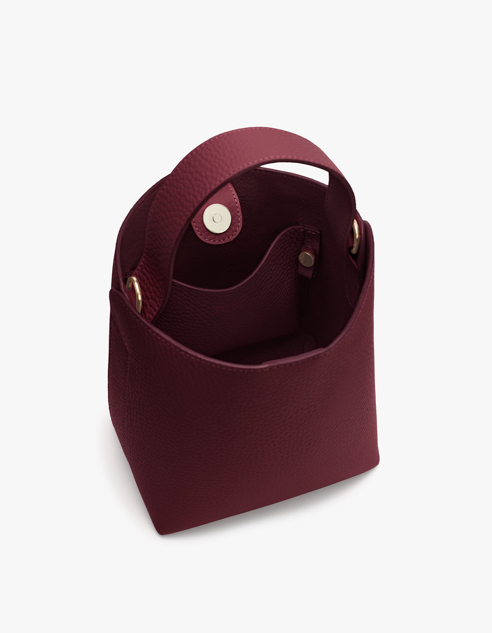 Open handbag with round handles and button closure on top.