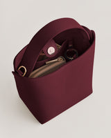 Handbag with an open top, showing a zippered pouch and a keyring inside.