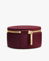 Round zippered jewelry case with a small pull tab.