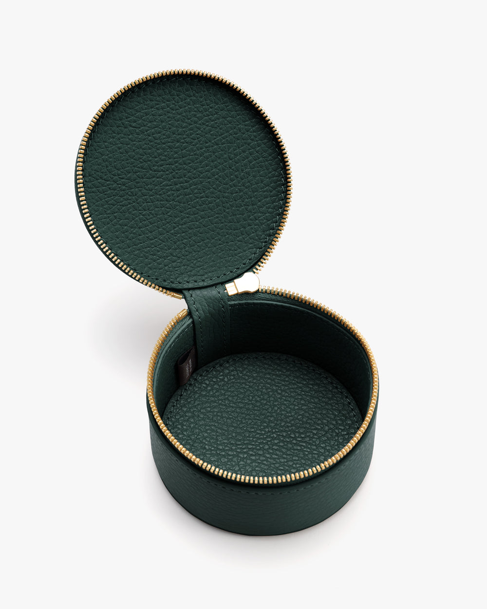 Round leather travel case with zipper, open to show inside compartments.