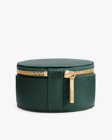 Round leather case with a zipper and small handle.