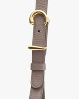 Close-up of a textured belt with gold buckle.