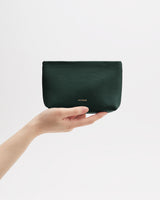 Hand holding a small pouch against a plain background