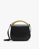 A handbag with a gold handle and a shoulder strap is shown.