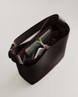 Open handbag with compartments and items inside.