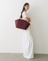 Person in long dress holding a large handbag on their shoulder