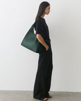 Person in profile with a wide-leg outfit carrying a shoulder bag