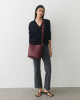 Person standing with bucket bag wearing casual outfit and sandals