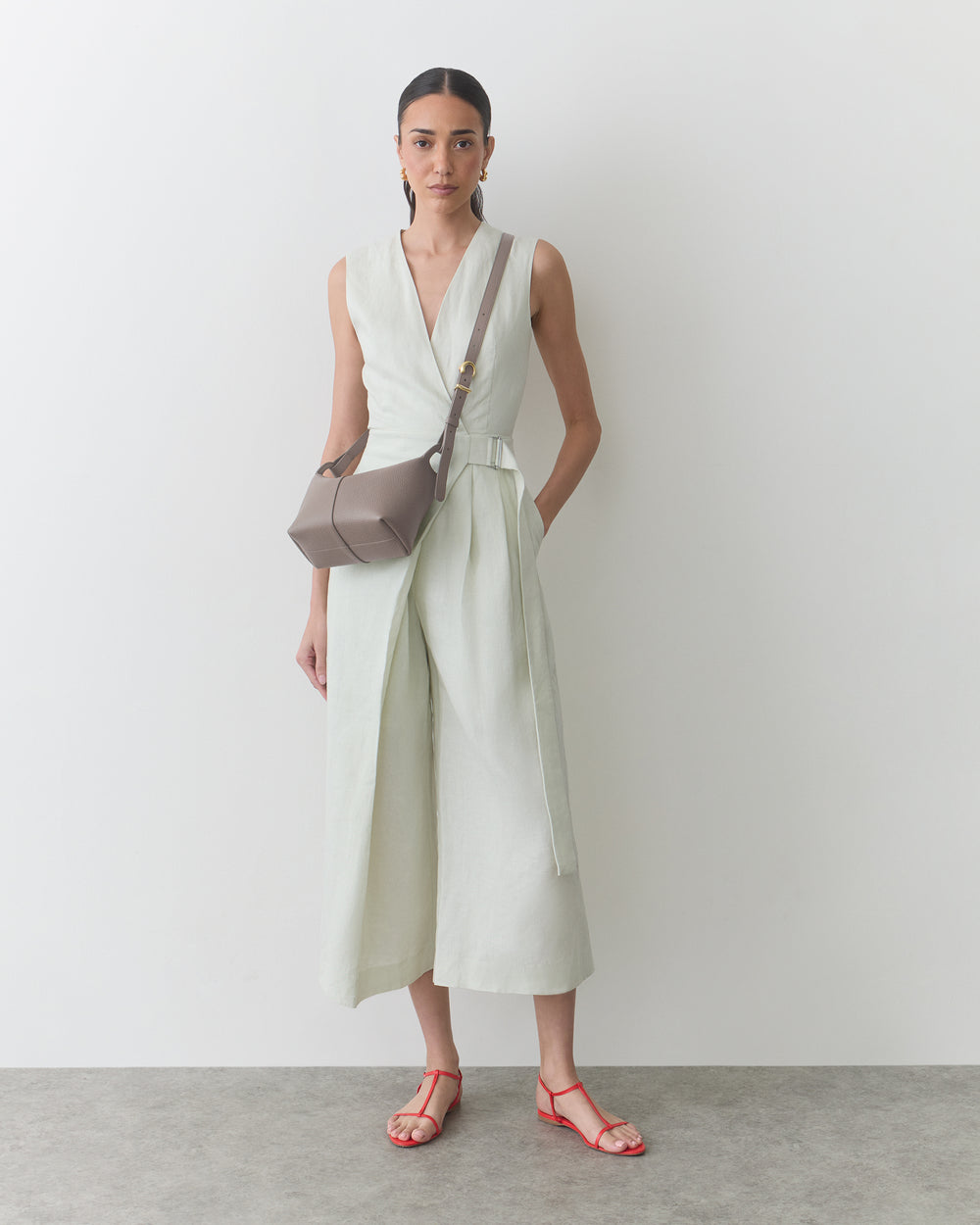 Person wearing a sleeveless dress with a crossbody bag.