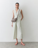 Person wearing a sleeveless dress with a crossbody bag.