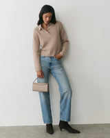 Person in casual outfit holding a small handbag