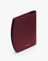 Textured wallet standing upright on a plain surface.
