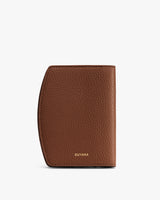 Textured passport holder with a curved edge and small brand logo.