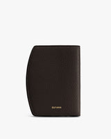 Textured leather wallet standing upright on a neutral background.