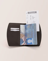 Open passport holder with visible passport and boarding pass.