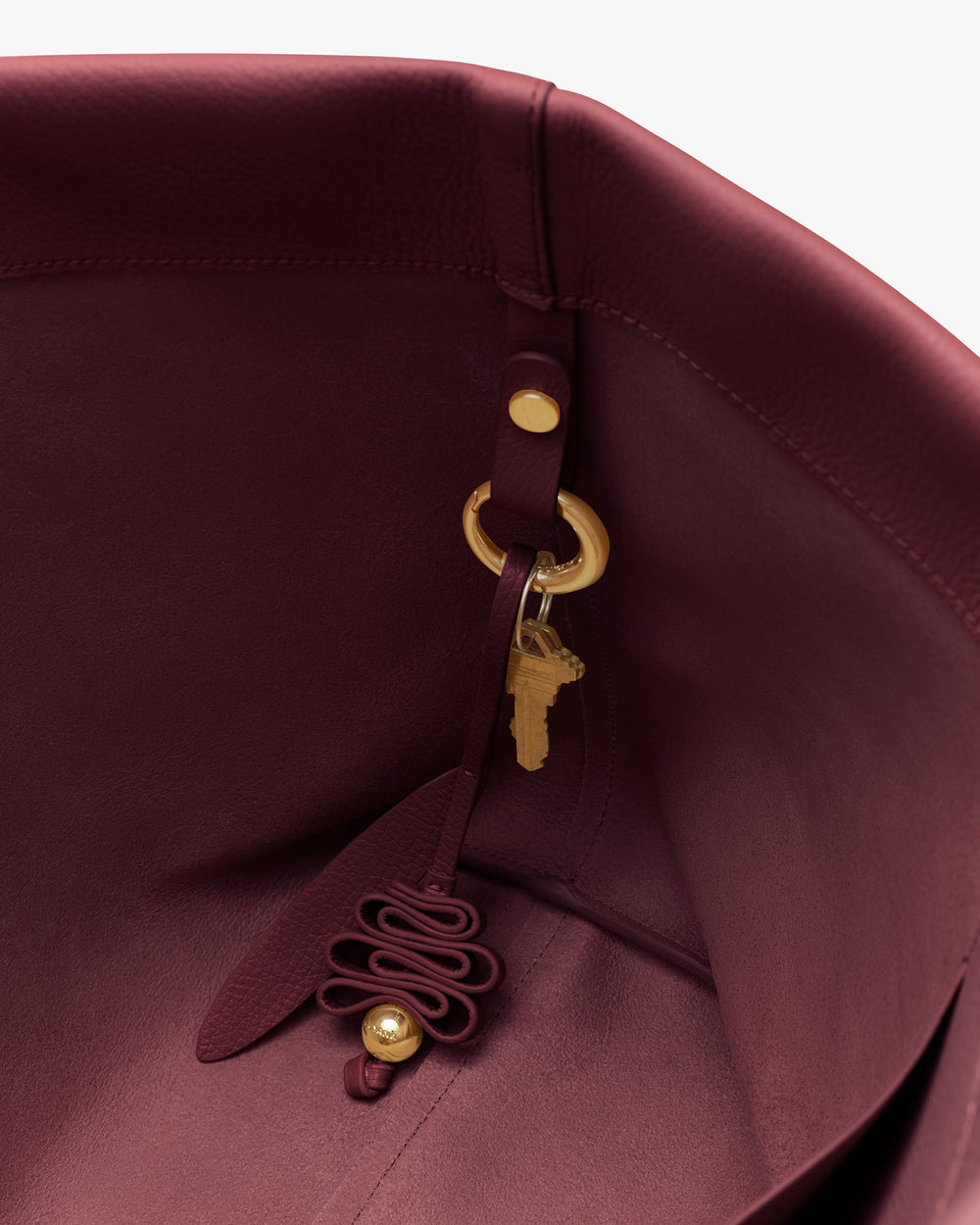 View inside a handbag with a decorative keychain attached.