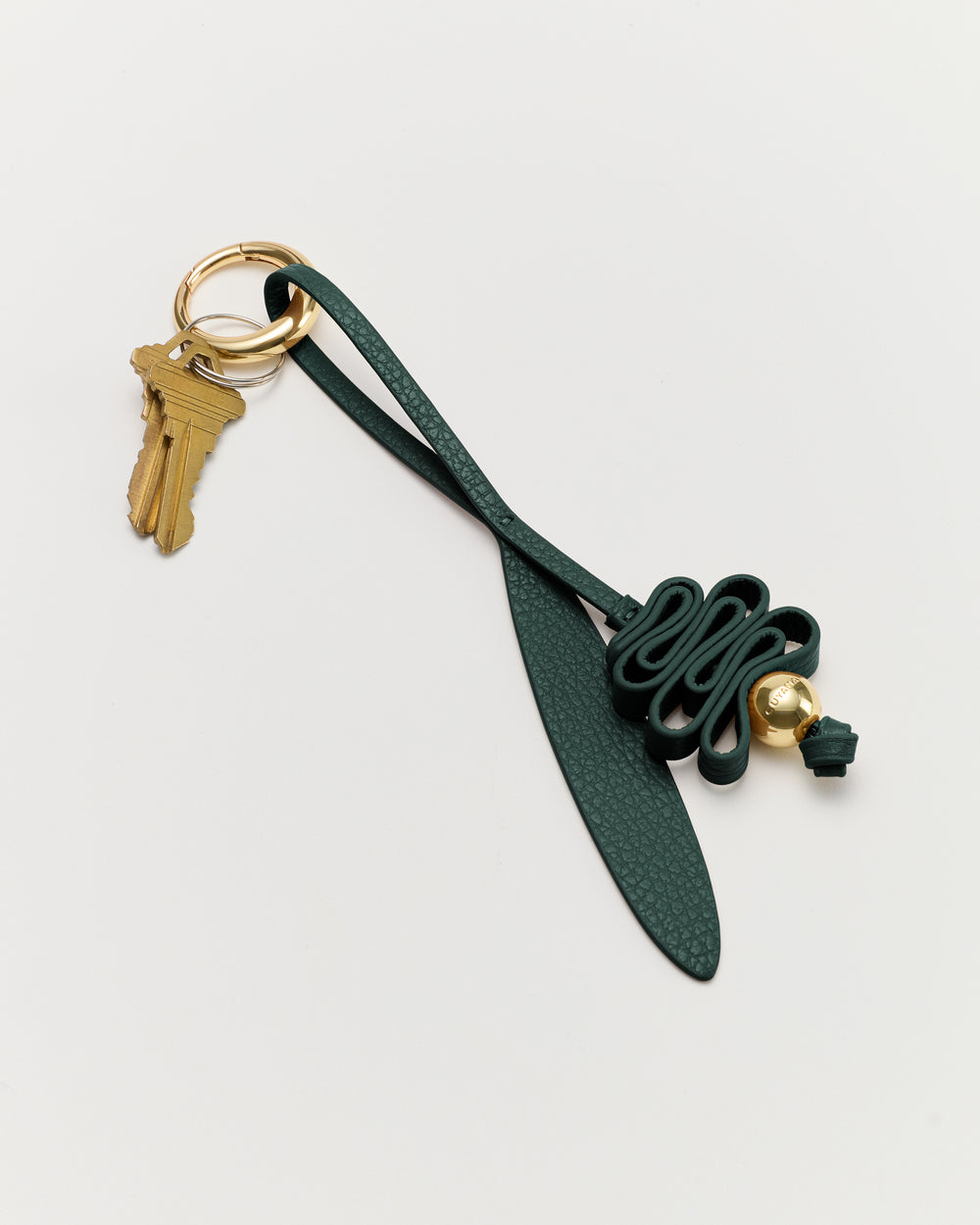 Keychain with a leaf-shaped charm and a decorative knot with attached keys.