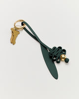 Keychain with a leaf-shaped charm and a decorative knot with attached keys.