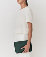 Person holding a rectangular clutch bag against side