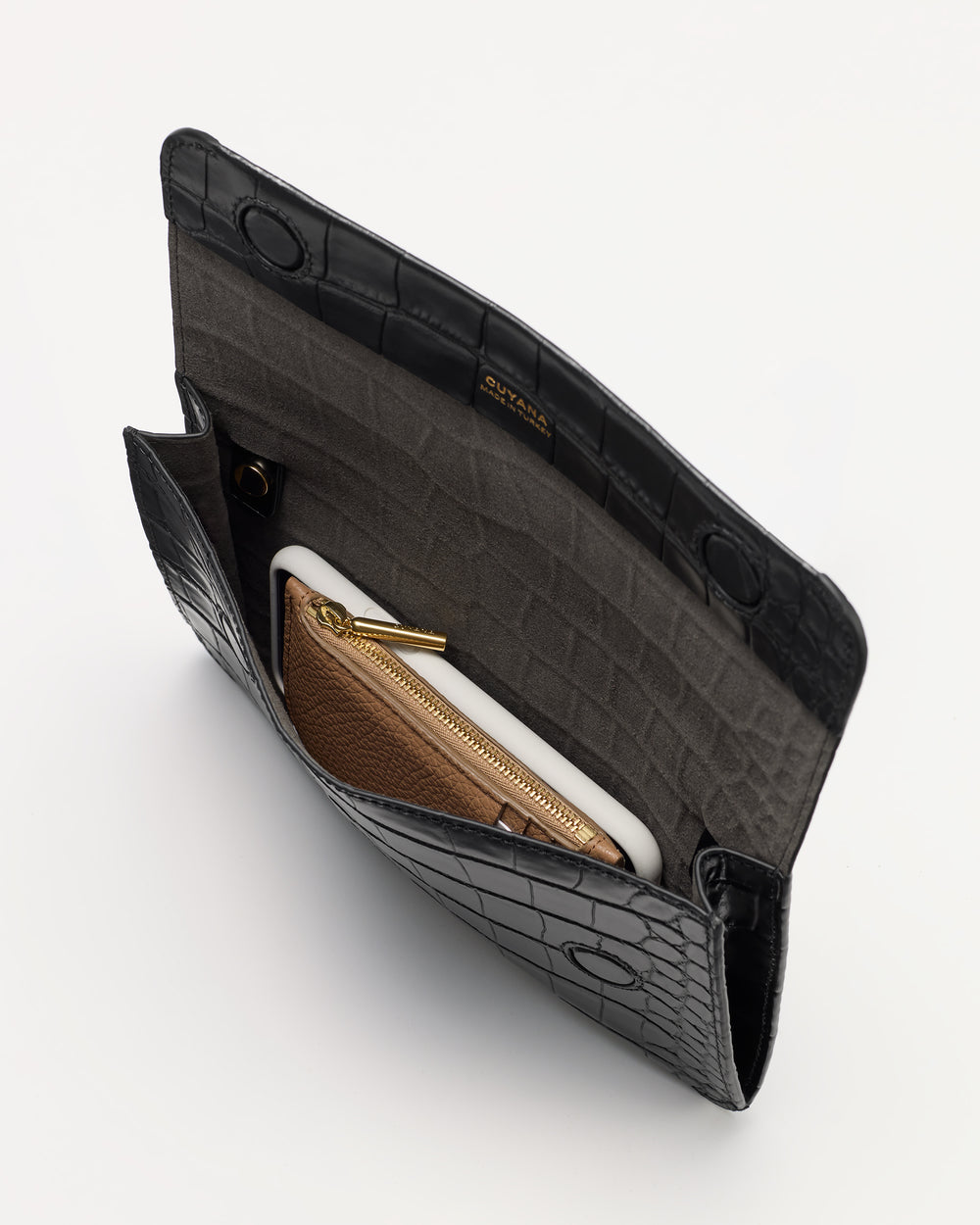 Open croc-embossed leather clutch with a wallet and phone inside.