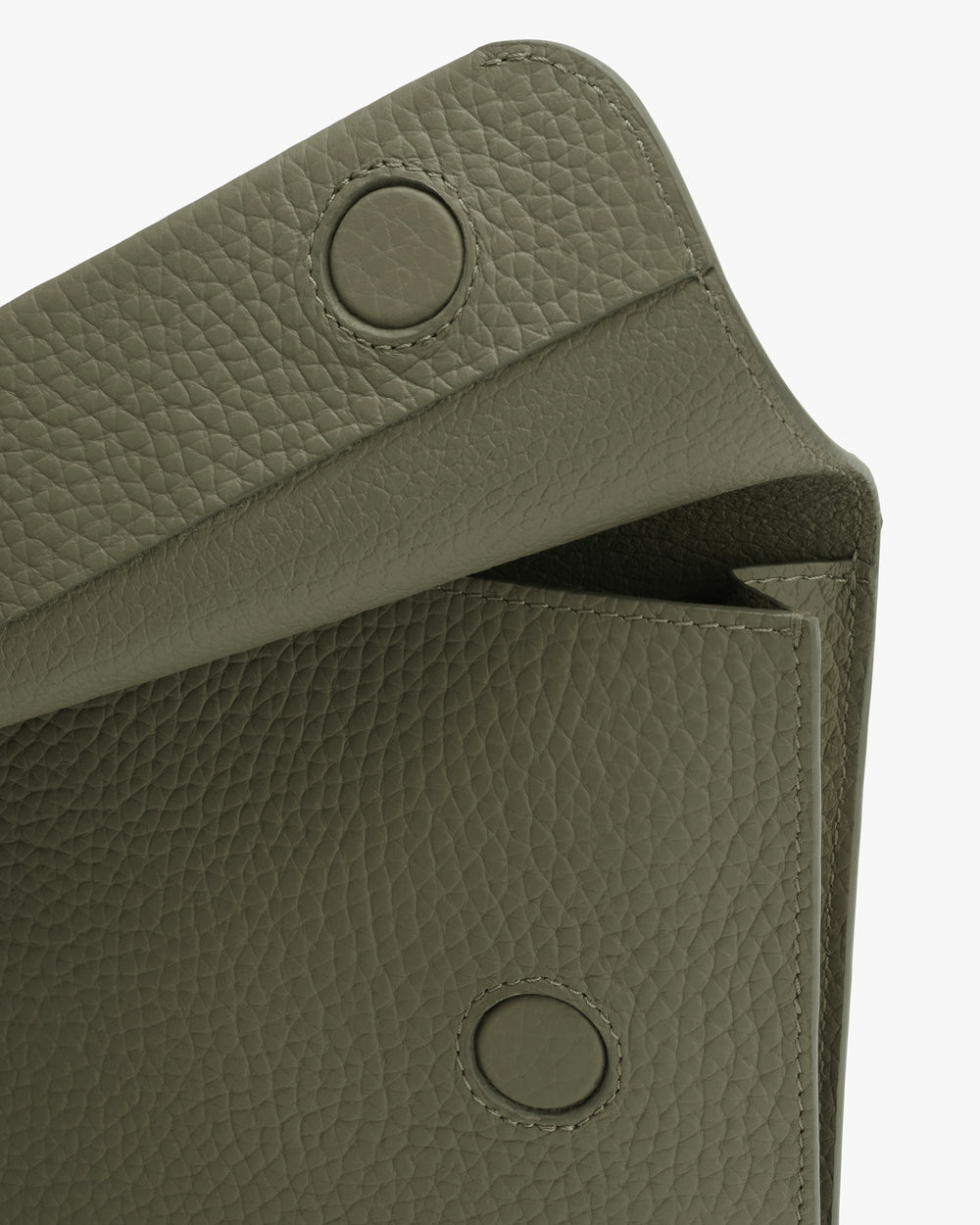 Close-up of textured bag with circular magnetic snap closures