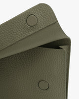 Close-up of textured bag with circular magnetic snap closures